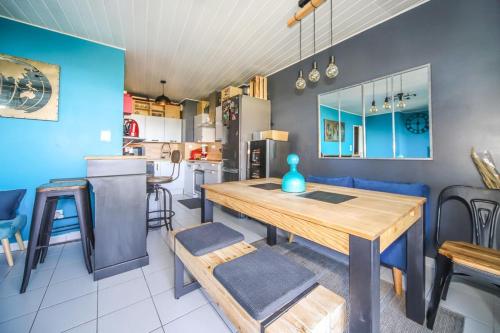 a kitchen and dining room with a wooden table and chairs at Grand T2 Montpellier Climatisation Terrasse Proche centre Ville et Plages in Montpellier