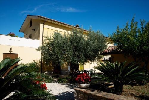 a building with trees and flowers in a yard at Agriturismo Il Casolare Di Nonno Mario in Manoppello