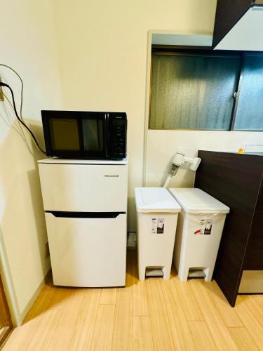 a microwave sitting on top of a refrigerator in a kitchen at 京墅-蓮 Kyosho Lotus in Kyoto