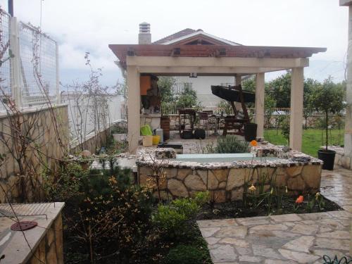 a gazebo with a pool in a garden at Apartments Anna in Dobrota