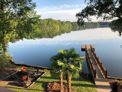 a man sitting next to a dock on a lake at Southern Comfort Cabin in Lake Murray Shores
