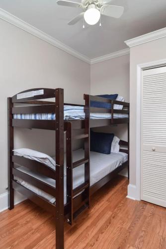two bunk beds in a room with a ceiling fan at Southern Comfort Cabin in Lake Murray Shores