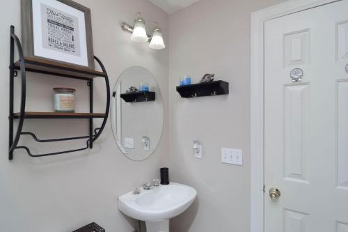 a white bathroom with a sink and a mirror at Southern Comfort Cabin in Lake Murray Shores