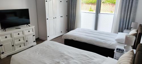 1 dormitorio con 2 camas y TV de pantalla plana en Apartment.Abel-Misburg en Hannover