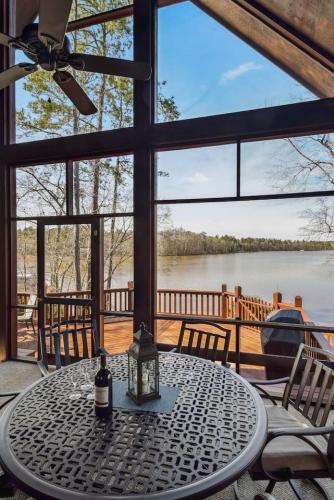 a table with a bottle of wine sitting on top of a porch at Southern Comfort Cabin in Lake Murray Shores
