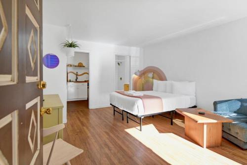 Un dormitorio blanco con una cama y un sofá. en The Rainbow Room - Studio Apt, en Columbia