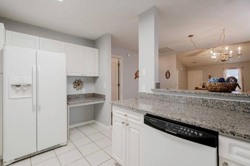 a kitchen with white cabinets and a white refrigerator at On Lake Time - Lake Murray in Chapin