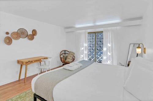 Dormitorio blanco con cama y mesa en The Botanical Suite en Columbia