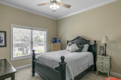 a bedroom with a bed and a ceiling fan at Water front Getaway w. Boat Docks / Fishing in Orange Beach