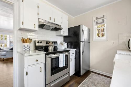 una cucina con armadietti bianchi e frigorifero nero di Blue Haven of Rosewood a Columbia