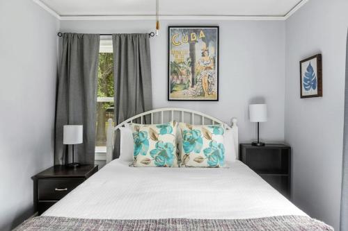 1 dormitorio con cama blanca y almohadas azules en Cute Cola Home - 3BR 1 BA, en Columbia