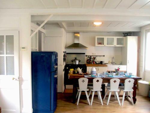 une cuisine avec un réfrigérateur bleu et des chaises à l'intérieur dans l'établissement Maison mer, jardin, plage, forêt, à Villerville