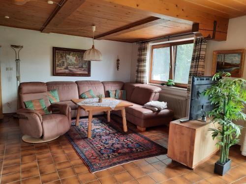 uma sala de estar com um sofá e uma mesa em Ferienhaus Knittel Verm nur Samstag auf Samstag em Murnau am Staffelsee