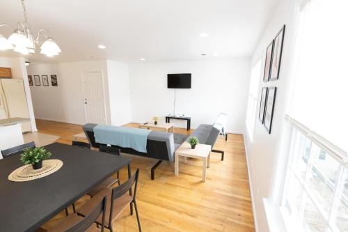 uma sala de jantar e sala de estar com mesa e cadeiras em Elegant & Spacious 3-bed Gem mins to NYC em Jersey City