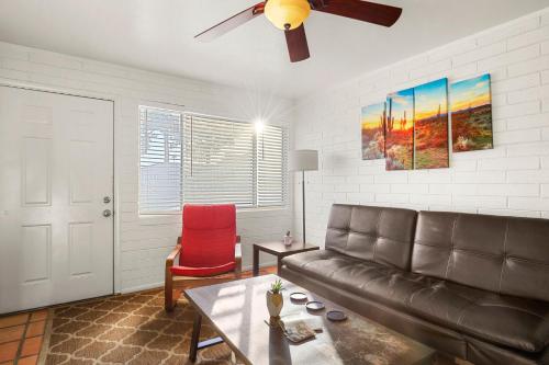 a living room with a leather couch and a red chair at Pinchot Dos - Old Town Scottsdale in Scottsdale