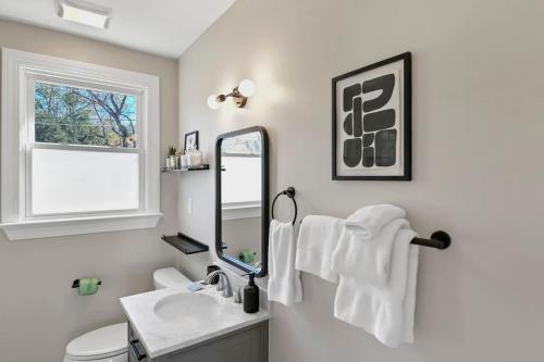 a bathroom with a sink and a mirror at Forest Acres Boho Home - 2BR in Columbia