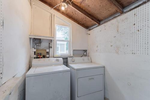 eine Waschküche mit zwei Maschinen und einem Fenster in der Unterkunft Prospect Place - 2BR 1 BA in Columbia