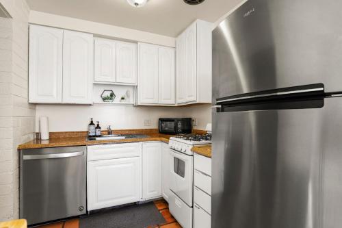 a kitchen with white cabinets and a stainless steel refrigerator at Pinchot Dos - Old Town Scottsdale in Scottsdale