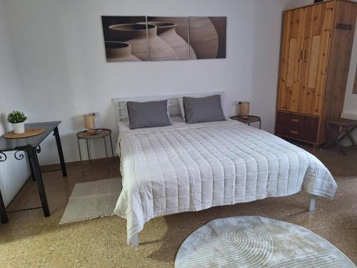 a bedroom with a bed with a white comforter at Dekel in Arad