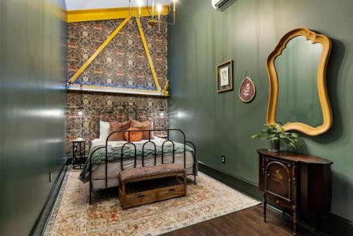 a bedroom with a bed and a green wall at Carraway - The Vestry on Read in Columbia