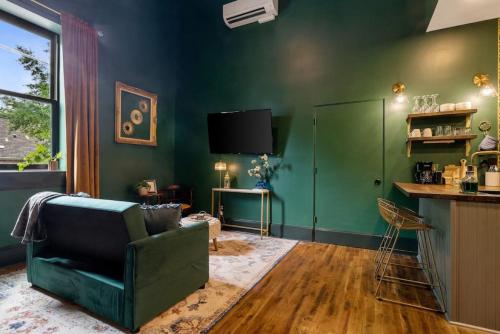 a living room with green walls and a green couch at Carraway - The Vestry on Read in Columbia
