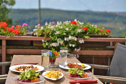 a table with plates of food on a balcony with flowers at Hotel-Restaurant Kelter in Esslingen