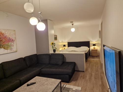 sala de estar con sofá y cama en Lägenhetshotell Varvet, en Ellös