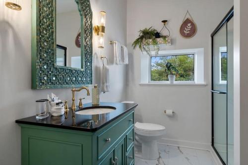 Un baño con lavabo, inodoro y espejo. en Gypsy - The Vestry on Read, en Columbia