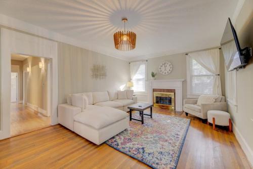 a living room with a white couch and a fireplace at Rose Hill Retreat-Mins to USC in Columbia