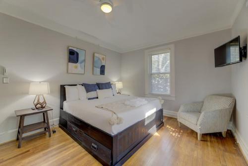 a bedroom with a large bed and a chair at Rose Hill Retreat-Mins to USC in Columbia