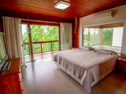 - une chambre avec un lit, une baignoire et des fenêtres dans l'établissement Mansão nas Montanhas, à Domingos Martins