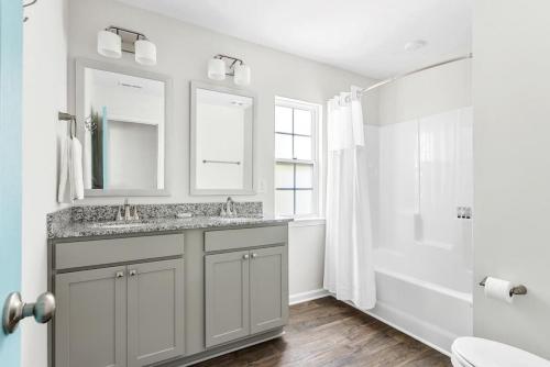 a white bathroom with a sink and a tub at WeCo Duplex -8 BR- Sleeps 16 in West Columbia