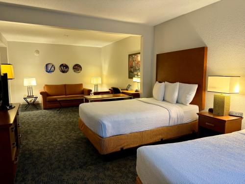 a hotel room with two beds and a couch at La Quinta by Wyndham Bannockburn-Deerfield in Bannockburn