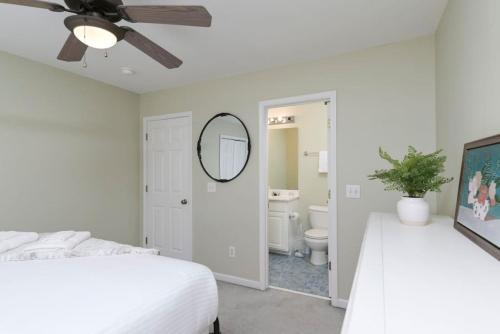 Un dormitorio blanco con una cama y un espejo. en Cozy 2BR Home Near Ft Jackson, en Columbia
