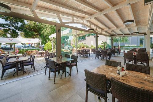 an outdoor dining area with tables and chairs and a patio at Paradise Hotel & Relax Center in Pomorie