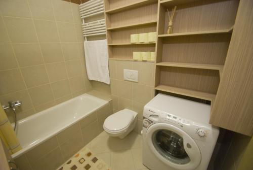 een badkamer met een toilet en een wasmachine bij Gozsdu Spacious Apartment in Boedapest