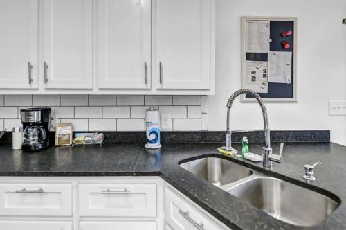 a kitchen counter with a sink and white cabinets at Modern Gem in Columbia in Columbia