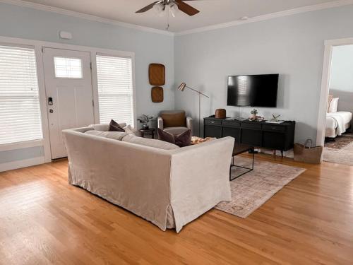 a living room with a couch and a flat screen tv at The Congaree Cottage in Cayce