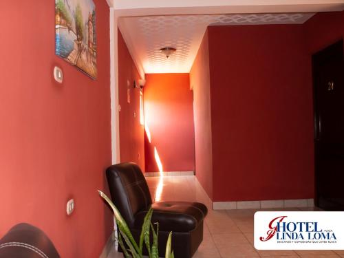 ein Wartezimmer mit einem Stuhl und roten Wänden in der Unterkunft Hotel Linda Loma in Quetzaltenango