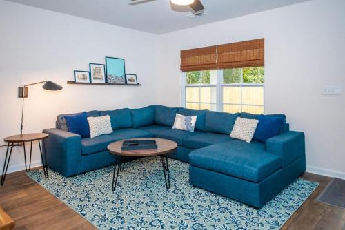 a living room with a blue couch and a table at Fun 4BD w 75 inch TV in West Columbia