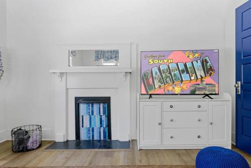 a living room with a tv and a white dresser at Urban Farmhouse-Sleeps 8 in West Columbia