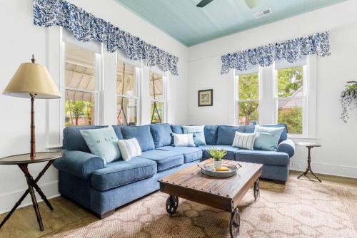 a blue couch in a living room with windows at Urban Farmhouse-Sleeps 8 in West Columbia
