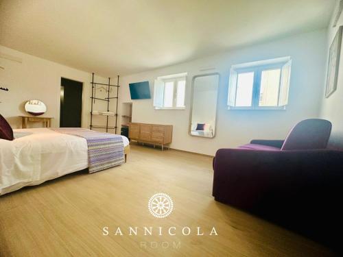 a bedroom with a bed and a couch and windows at San Nicola Room e spa in Gravina in Puglia
