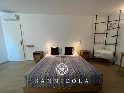 a bedroom with a bed with a sambucia sign on it at San Nicola Room e spa in Gravina in Puglia