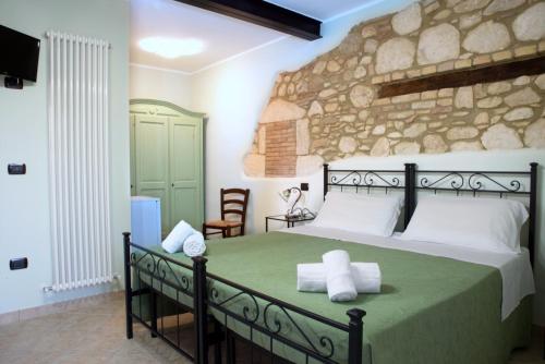 1 dormitorio con 1 cama grande y pared de piedra en Agriturismo Il Casolare Di Nonno Mario, en Manoppello