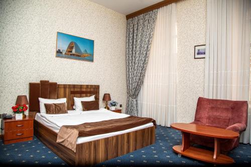 um quarto de hotel com uma cama e uma cadeira em Hotel & Bistro em Baku