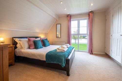 a bedroom with a bed and a large window at Isis Lakes 50, Natterjack Lodge - P in South Cerney