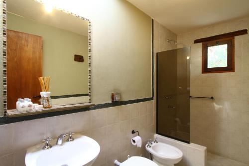 a bathroom with a sink and a toilet and a mirror at Hotel El Reposo Del Diablo in Tilcara