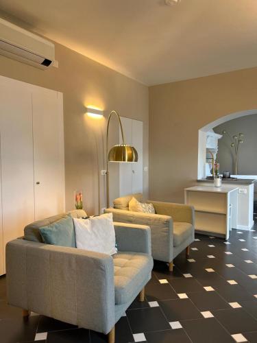 a living room with two couches and a kitchen at Divina Vita Apartments in Varenna