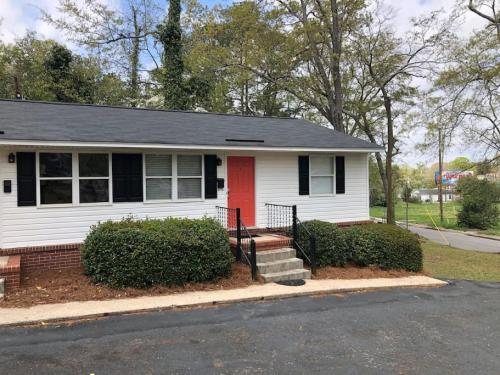 a white house with a red door on a street at Modern Renovated Apartment in Columbia